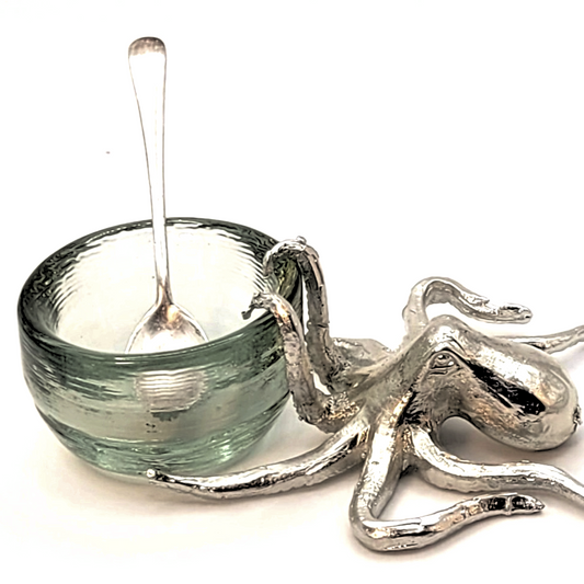 Decorative glass bowl and pewter octopus on a white background